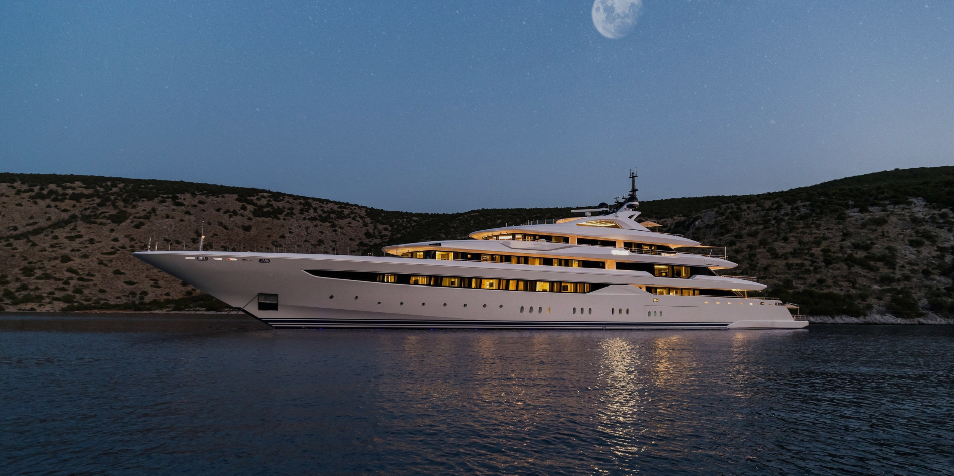 A charter yacht at anchor at dusk