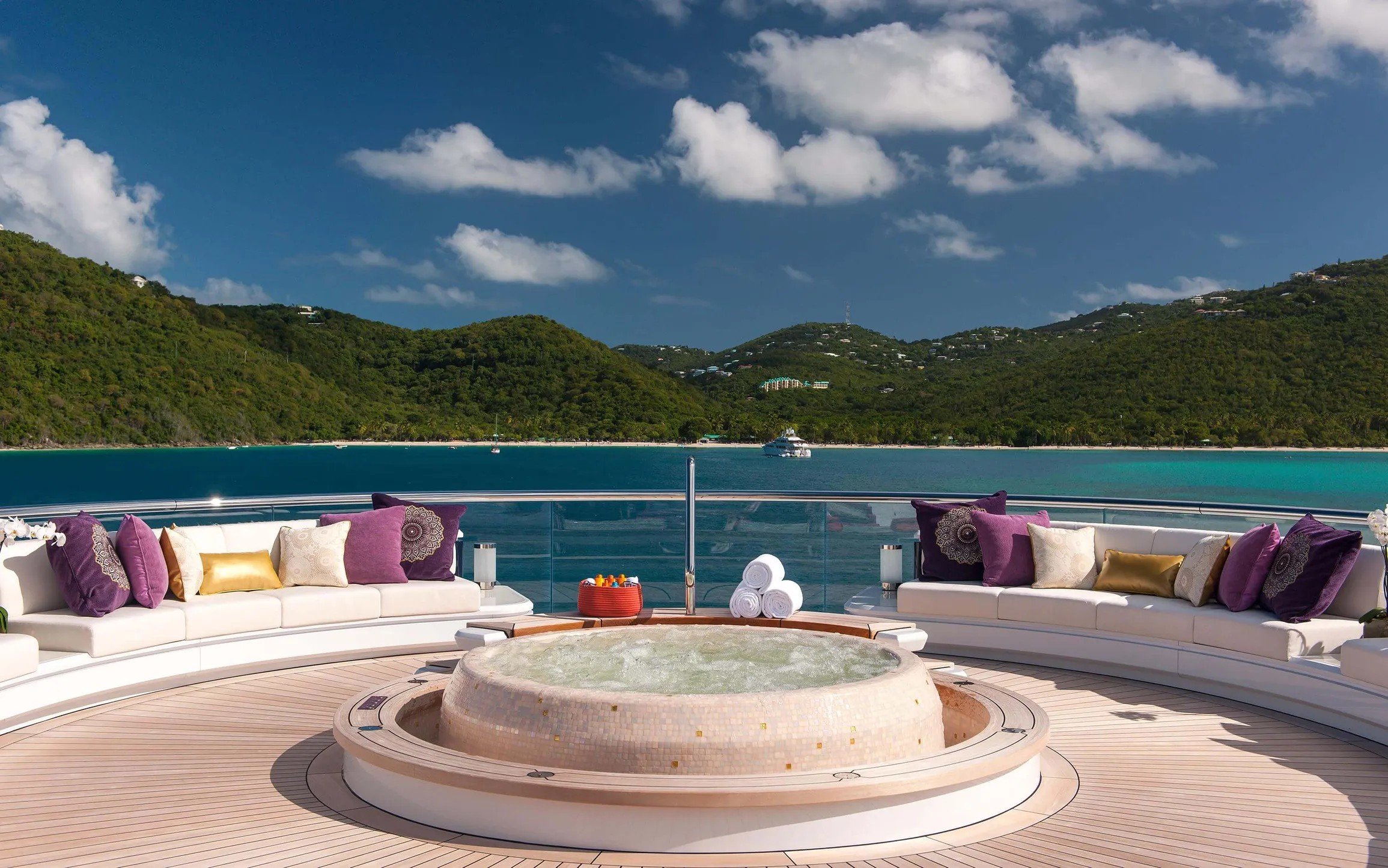 Sun deck spa pool on the superyacht Solandge, overlooking a green bay